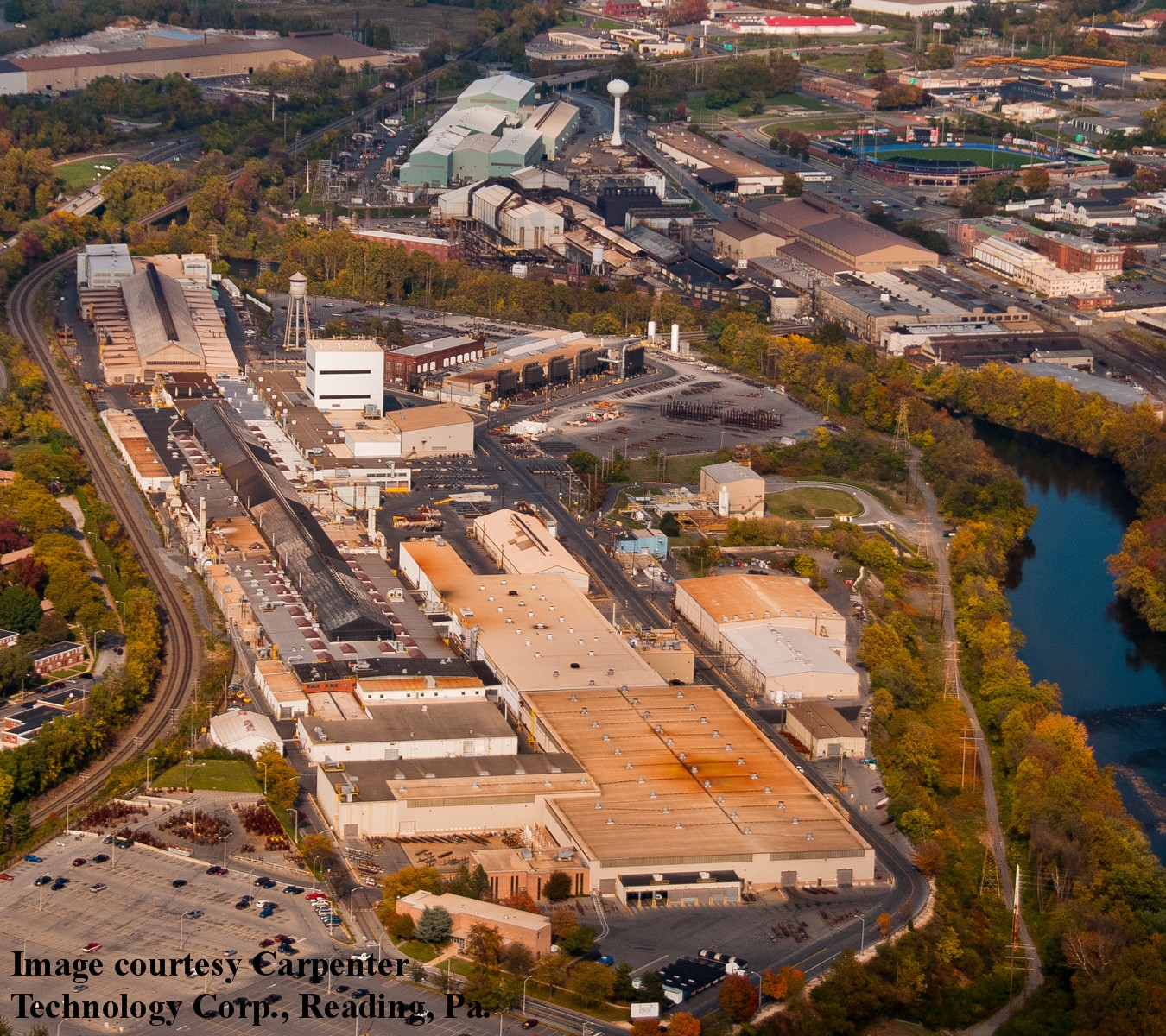 Vista aérea da usina da Carpenter Technology Corporation em Reading, Pensilvânia, com galpões de laminação, chaminés e pátio de estocagem.