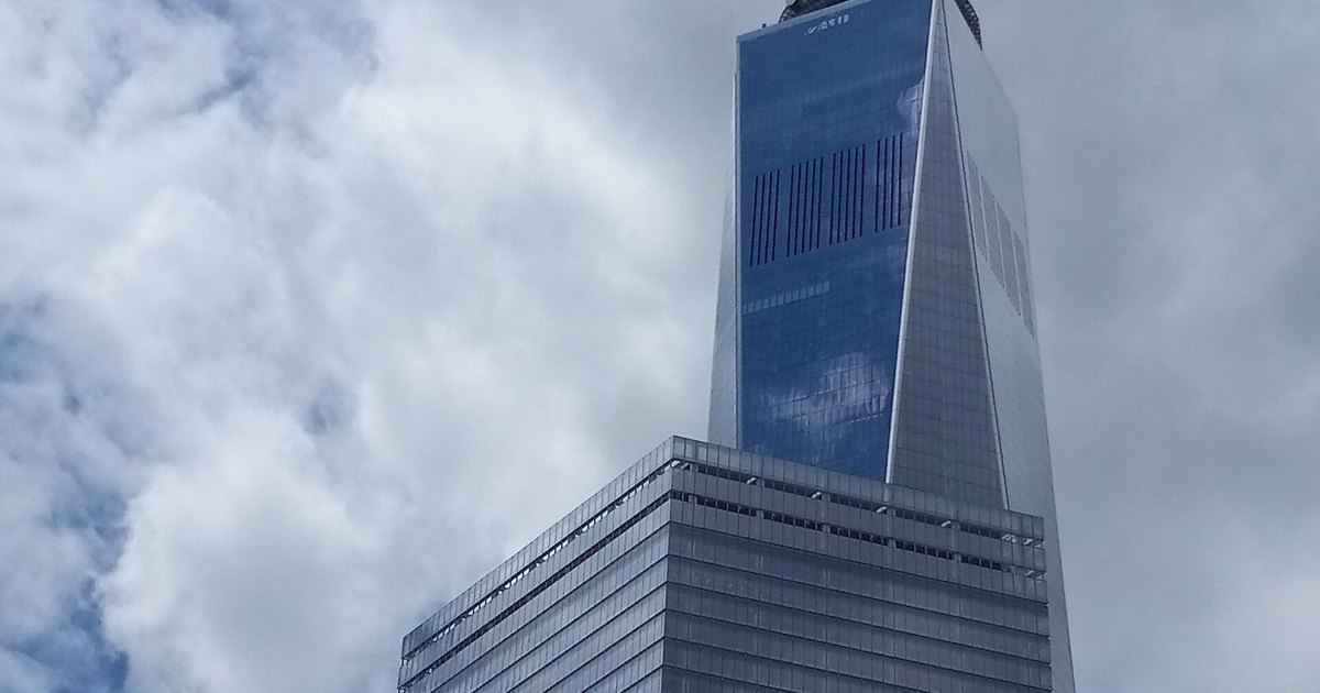 O One World Trade Center, em Nova York, visto de baixo contra um céu nublado.
